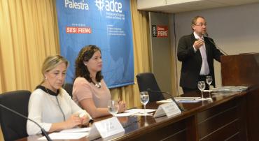 Secretário municipal de Governo, Paulo Lamac, profere palestra de pé; ao seu lado, sentads, as secretárias municipais de Assistência Social, Segurança Alimentar e Cidadania, Maíra Colares, e de Política Urbana, Maria Caldas.