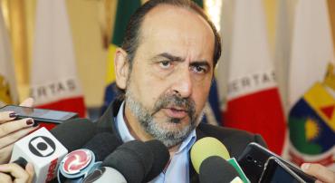 Prefeito Alexandre Kalil em coletiva à imprensa, rodeado por microfones