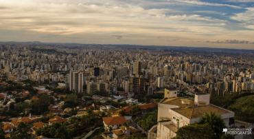 Foto da cidade de Belo Horizonte, com prédios e céu com nuvens à vista.