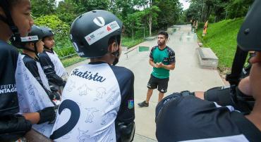 Professor de skate fala para alunos em parque
