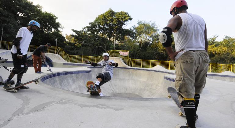 Quatro skatistas fazem manobras em pista do Parque Lagoa do Nado