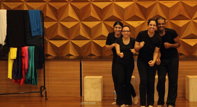 Atores no palco interpretando uma das cenas propostas pela plateia.