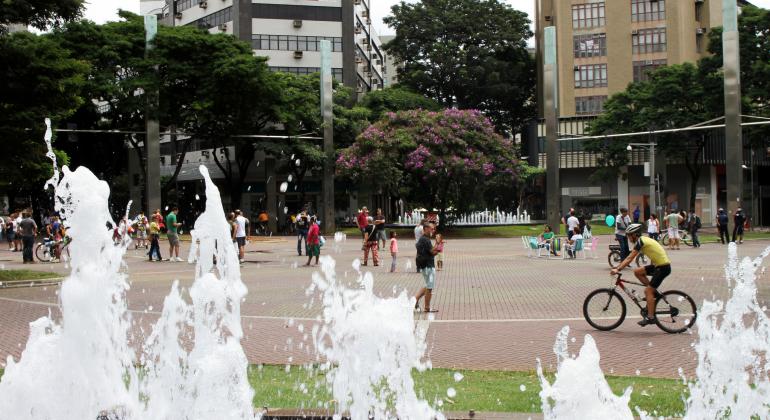 Foto: Amira Hissa/PBH Detalhe da fonte na praça da Savassi com vários ciclistas ao fundo.
