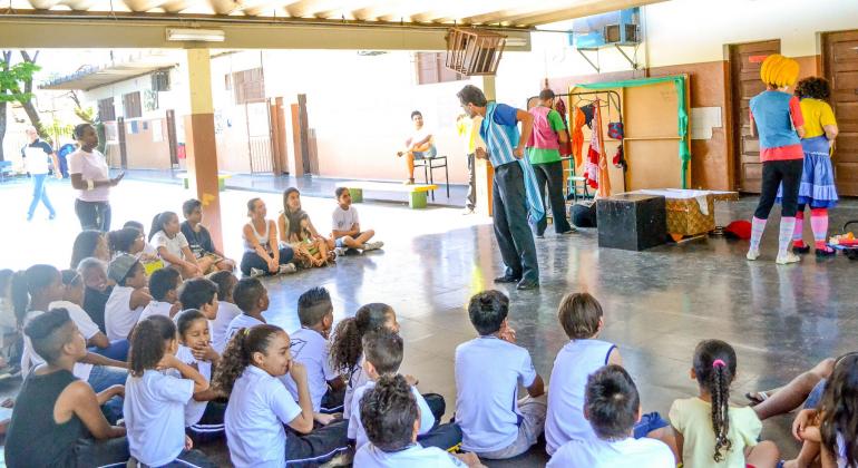 Membro do teatro se apresenta paa mais de trinta crianças.