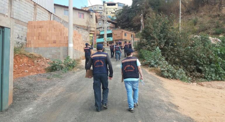 Cerca de dez técnicos da Defesa Civil sobem rua para fazer cadastramento de moradores nos arredores da Rua Sustenido, no bairro São Lucas.