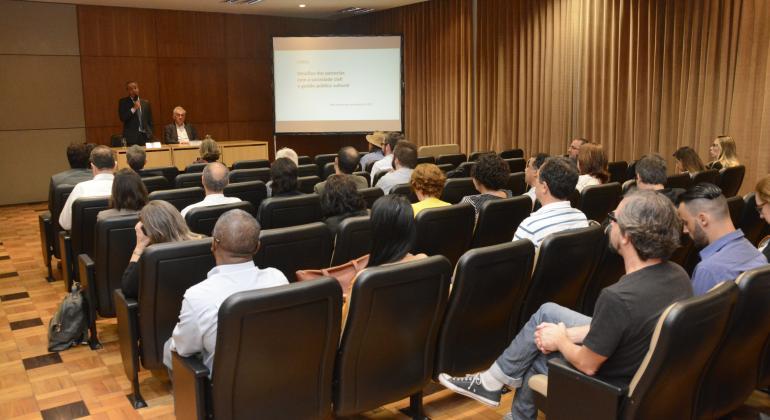 Dois palestrantes ministram cursos para mais de dez pessoas em sala.