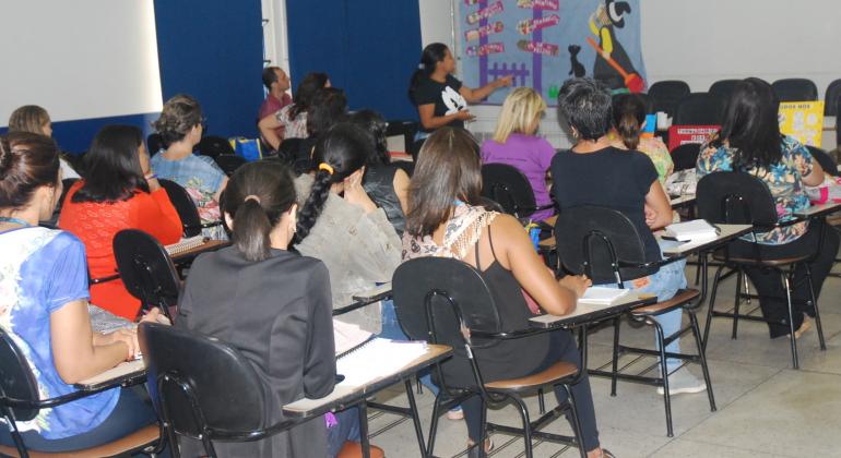 Cerca de onze pessoas sentadas em uma sala, assistindo a exposição de um palestrante.