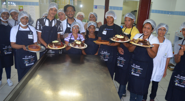 Cerca de catorze pessoas mostram os bolos feitos no programa Pão Escola do Mercado da Lagoinha.