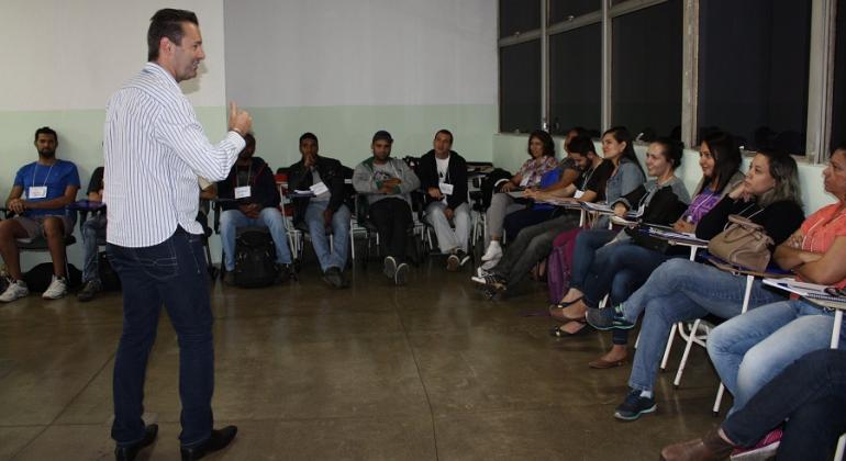 Homem faz palestra para mais de doze agentes de combate a endemias, sentados.