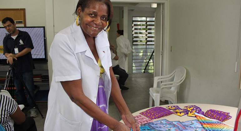 Técnica de saúde separa preservativos e material informativo contra a Aids, foto ilustrativa. 