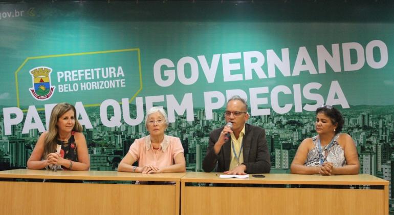 Mesa de abertura do lançamento do Diagnóstico do Idoso, com quatro pessoas: Sandra Mendonça Mallet, presidente do Conselho Municipal do Idoso; Laura Wong, professora do Centro de Desenvolvimento e Planejamento Regional da UFMG; José Crus, subsecretário de Assistência Social; Geisa Moreira, diretora de Políticas para a Pessoa Idosa.