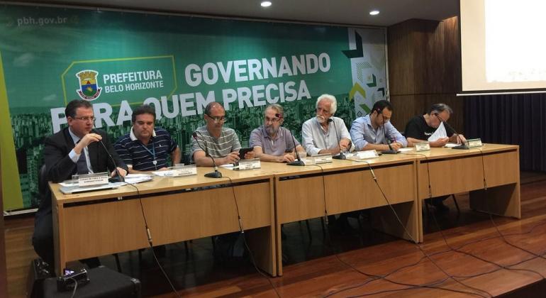 Sete membros do Conselho Municipal de Meio Ambiente sentados em uma mesa. 