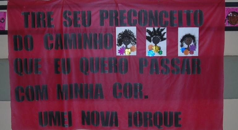 Cartaz produzido por crianças com os dizeres: "Tire o seu preconceito do caminho, que eu quero passar com a minha cor. Umei Nova Iorque"