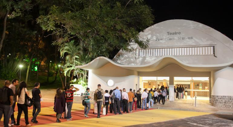 Teatro Francisco Nunes, no Parque Municipal, à noite, com fila de cerca de 50 pessoas