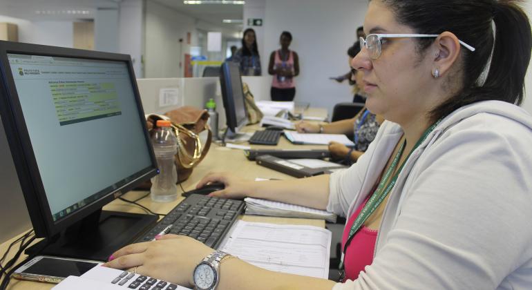 Estagiária usando computador em funções na Prefeitura