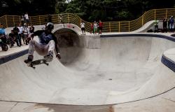 Skatista faz manobra na pista de skate do Parque Lagoa do Nado durante o dia. 