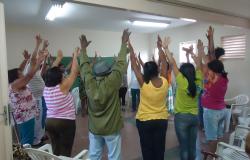 Idosos com as mãos para cima fazendo exercício