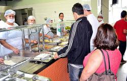 Três pessoas na fila do bandejão de Restaurante Popular.