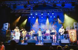 Grupo musical com sete integrantes se apresenta em um dos palcos do Carnaval de Belo Horizonte. 