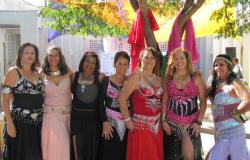 Sete mulheres vestidas de odaliscas, alunas da oficina de Dança do Ventre, posam para foto. 