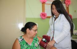 Enfermeira tira a pressão de paciente em centro de saúde